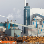 Biomass waste to energy facility with feedstock storage and industrial processing systems